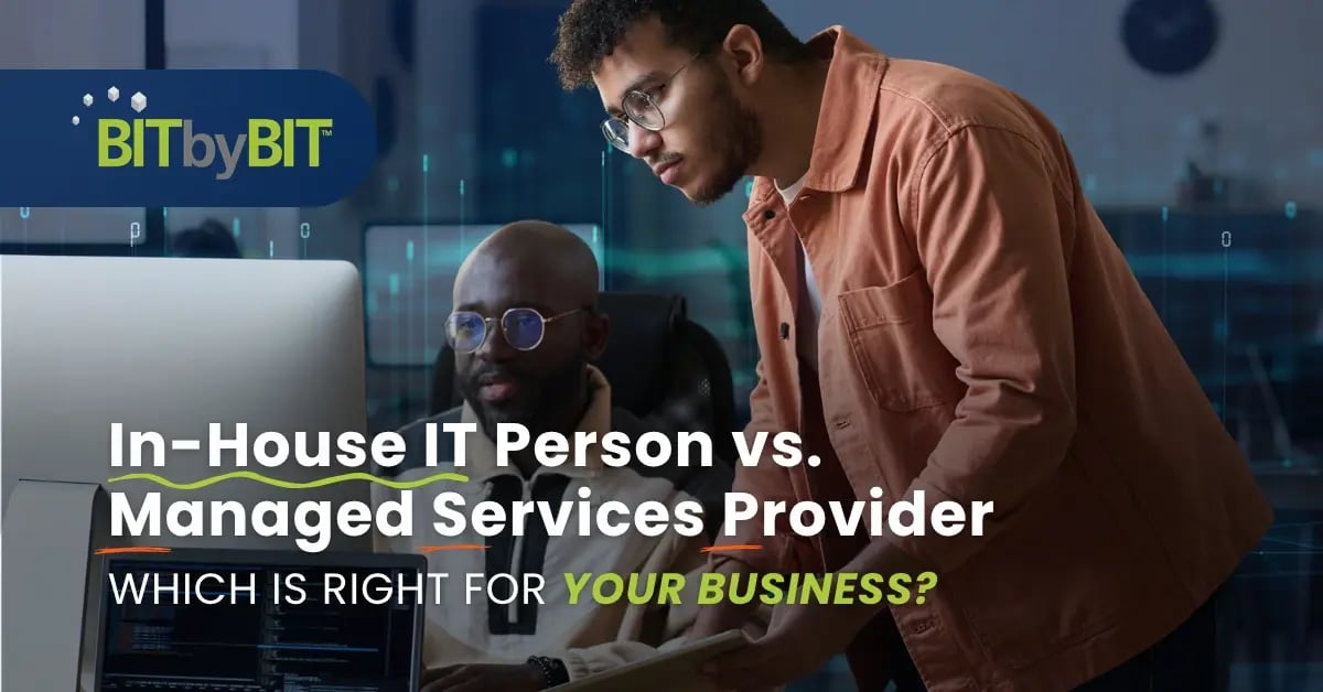 Two professionals review a screen together; the desk-side support could be in-house IT or from a managed services provider.