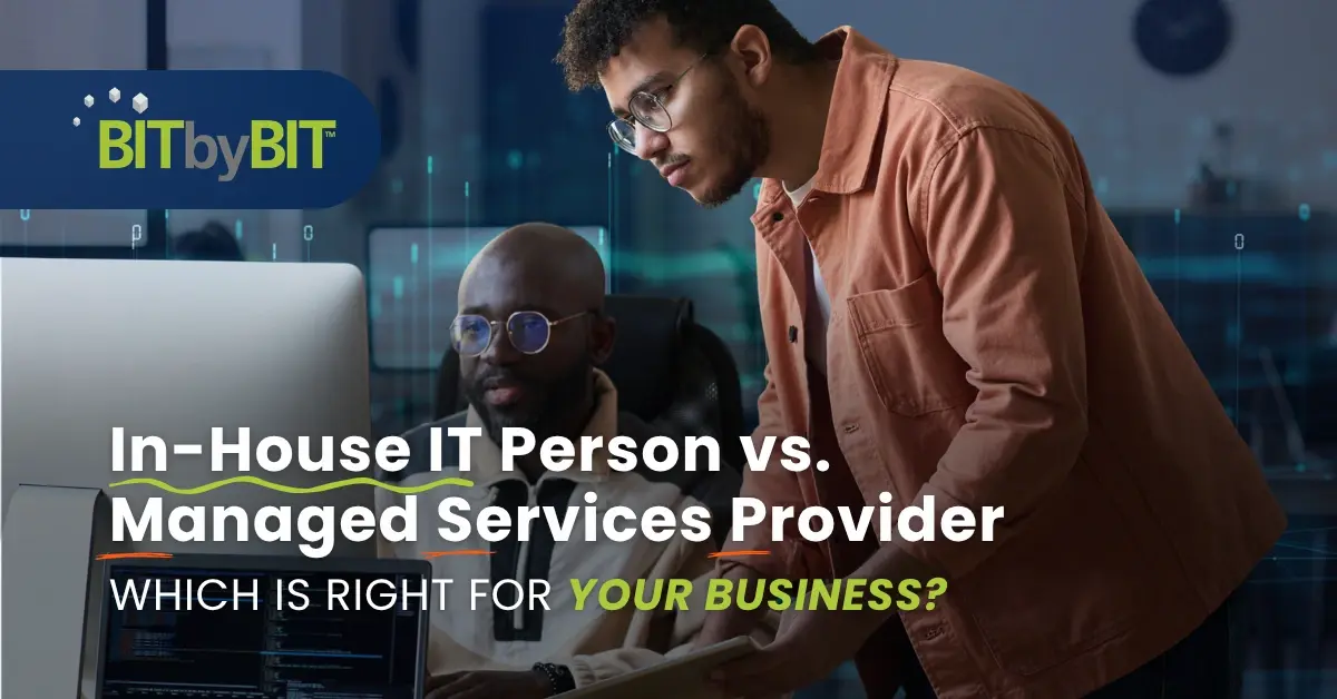 Two professionals review a screen together; the desk-side support could be in-house IT or from a managed services provider.